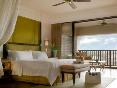 Suite bed room with balcony of a luxury resort on a sunny day